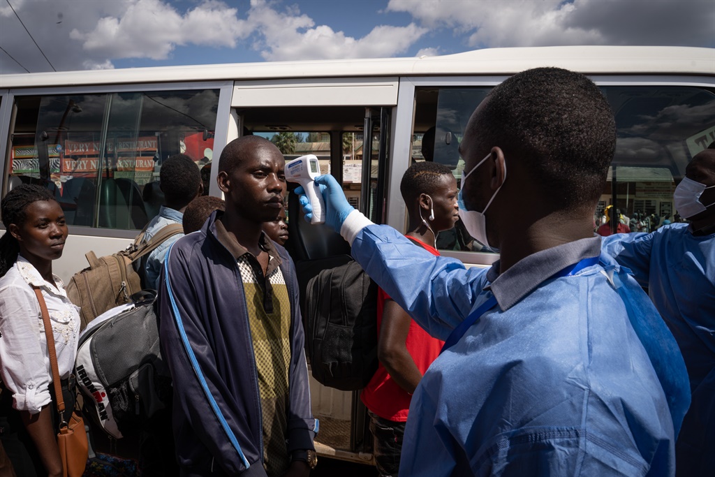 A staff of the Rwanda Biomedical Centre screens passengers at a bus station in Kigali, Rwanda.