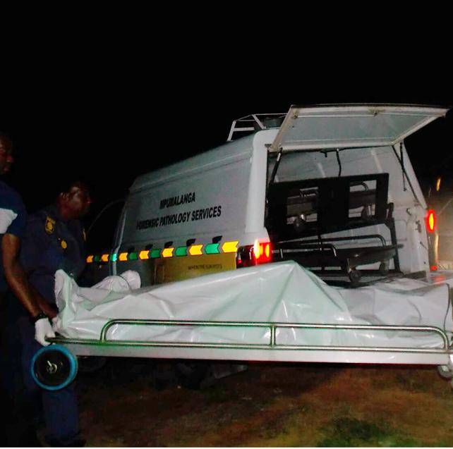 Cops carry the body of one of the suspects to a forensic pathology van after he was allegedly beaten to death by an angry mob.         Photo by                  Tlangelani Khosa