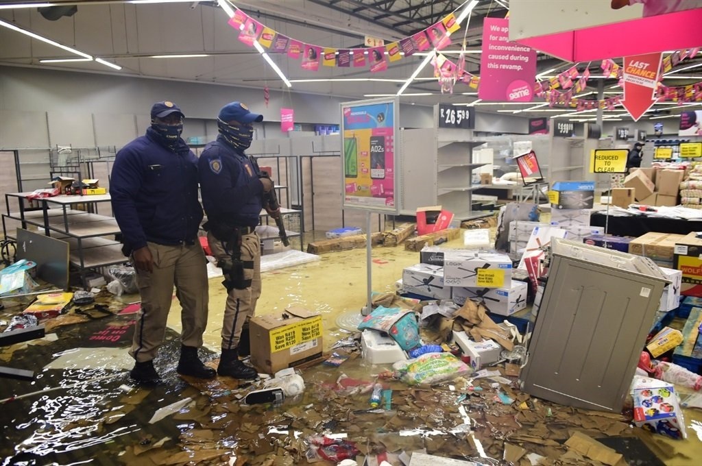 Officers in one of the stores that was looted and damaged during the 2021 July unrest. Photo by Morapedi Mashashe